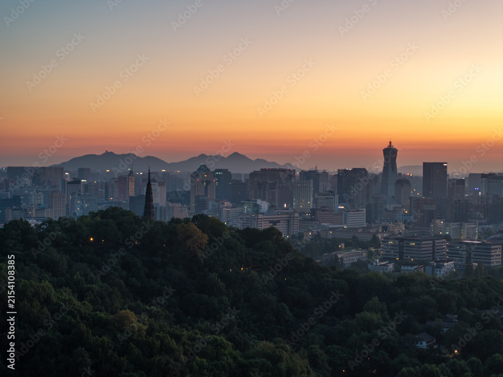 Fototapeta premium city skyline silhouette at dusk with mountains in the background