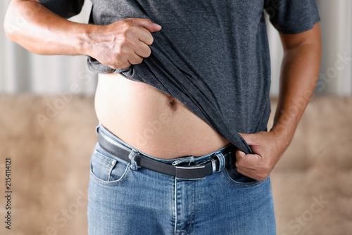 Overweight man belly fat, obesity, excess weight, visceral fat, unhealthy lifestyle, weight loss, metabolic health, and healthcare concept, close-up