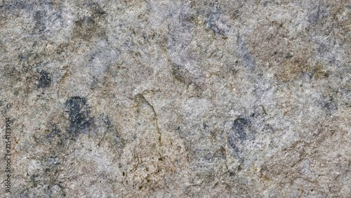 Obraz na plátne Rough natural stone surface with a highly detailed uneven texture, featuring fine-grained mineral particles, gritty abrasive patterns, faint random fracture lines, cracks, crevices