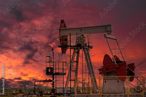 Obraz na płótnie Oil Pumpjack at Dramatic Red Sunset in Petroleum Field