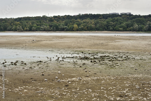 Bild auf Leinwand Low river water level on the Danube with shells at the bottom of a drying riverb