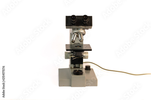Foto Classic scientific microscope with binocular viewing head, objective turret, precision mechanical stage and detached microscope illuminator, photographed against a clean white background