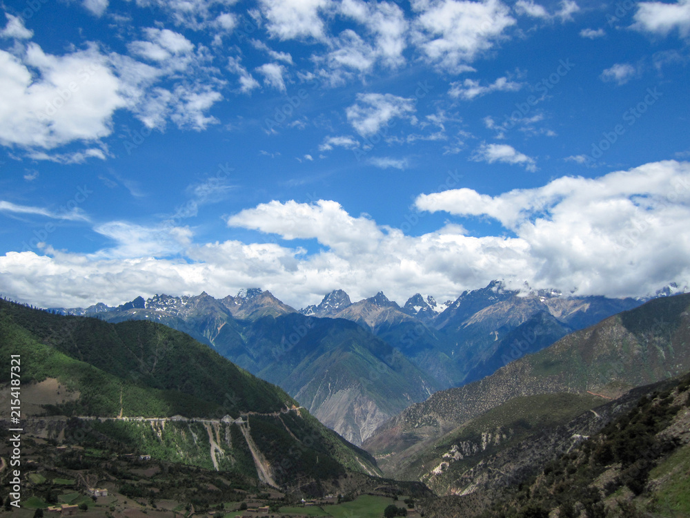 Fototapeta premium Beautiful mountain range under blue sky with white clouds