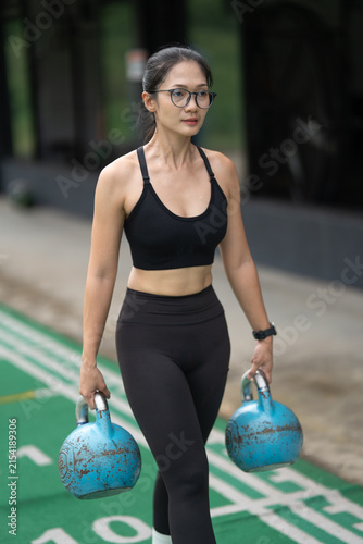 Canvastavla Woman carrying kettlebells on running track