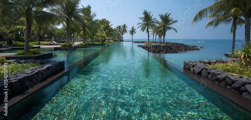 swimming pool at the bank of the luxurious beach glass platted with sierra blue water abstract backgroiund 