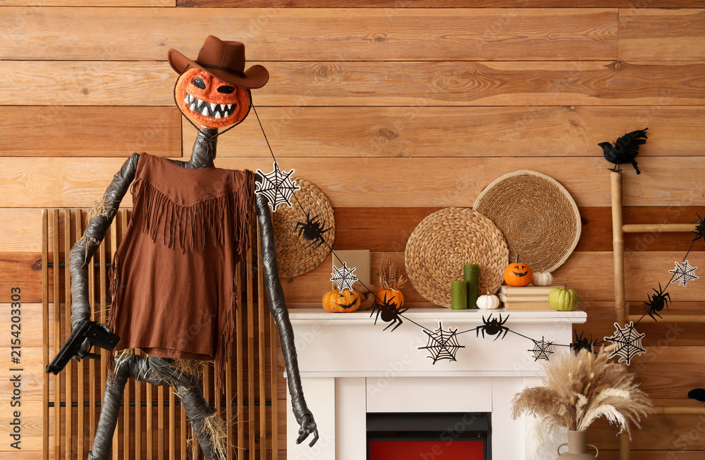Obraz premium Interior of festive living room with Spooky Halloween monster and autumn decorations on fireplace