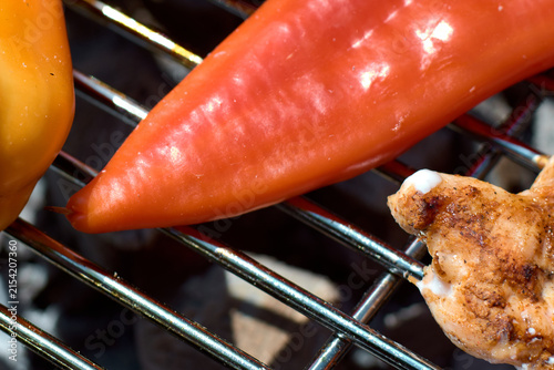 Quadro su tela Close-up of fresh colorful bell peppers grilling on a hot metal barbecue grate