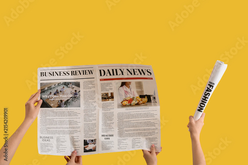 Women with newspapers on yellow background