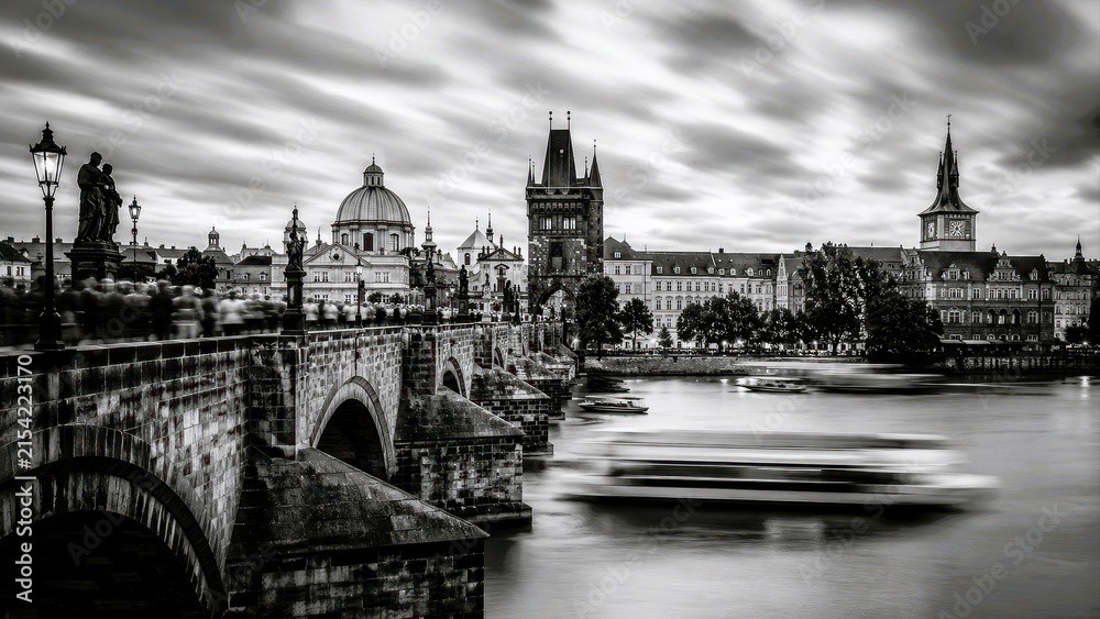 Fototapeta premium Monochrome long exposure landscape of historic bridge and city skyline with river motion and dramatic sky