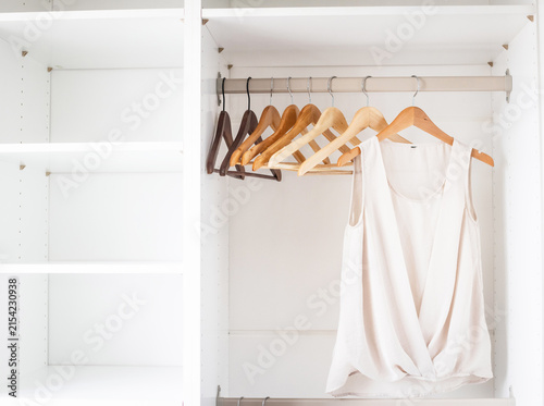 Bild auf Leinwand White shirts hanging neatly in closet, organized storage