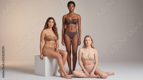 Four diverse individuals posing naturally in minimalist studio setting for lifestyle branding and body positivity campaigns