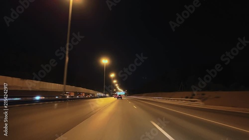 Timelapse night highway with streetlights and vehicles on multi-lane road under