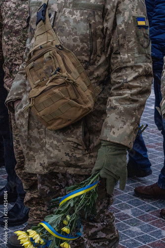 Photography Ukrainian soldier holding yellow and blue flowers