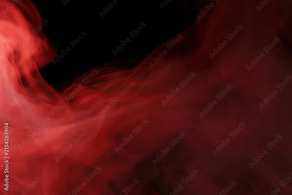 Fototapeta premium The Red Smoke Abstractly Dancing Through Darkness Creating Dramatic Cinematic Atmosphere