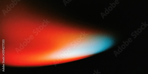 Abstract gradient of red, orange, white, and blue light against black