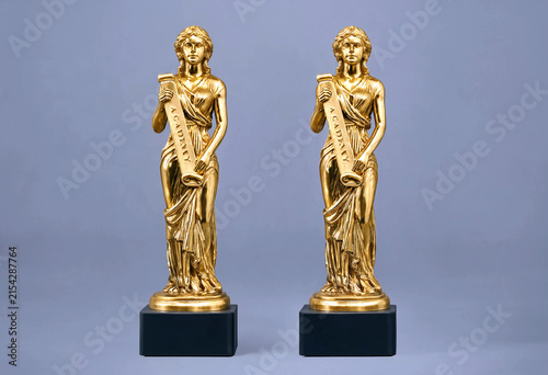 Elegant pair of golden statues holding scrolls standing on black bases perfect for awards or decorations