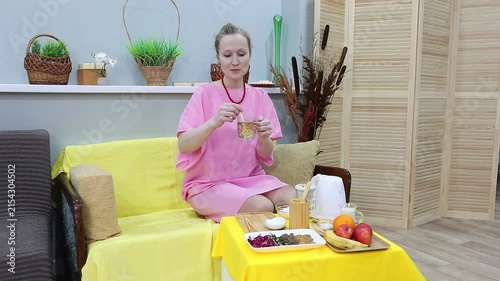 woman stirring buckwheat tea ku qiao in a mug with a spoon
