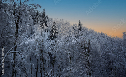 The first ray of morning sun illuminates the fresh snow on the lonely Alpine peaks