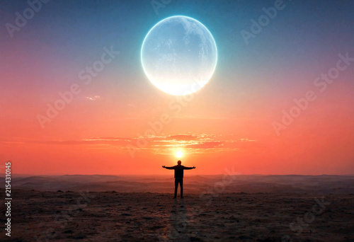Silhouette of a person standing with open arms under a giant moon and sunset sky scene