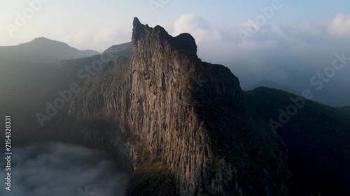 Aerial Drone Footage of Tebing Sumbing on Kelud Mountain Rising Above a Layer of Clouds in East Java, Indonesia. Dramatic Volcanic Cliff and Mountain Landscape Surrounded by Morning Cloudscape.
