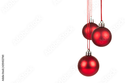 Three hanging red christmas ornaments with silver caps against a stark black background for festive holiday decorations