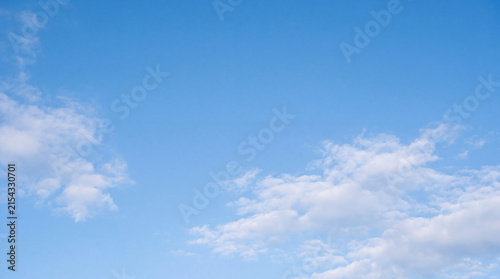Vast expanse of light blue sky adorned with delicate, scattered white clouds.