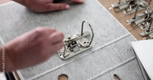 Hands carefully assemble a scrapbook, showcasing vibrant papers and decorations. The process unfolds in a cozy workspace filled with creativity and inspiration.