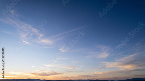 Foto Picturesque clear blue sky with gentle wispy clouds at sunrise or sunset