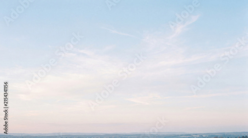 Bild auf Leinwand Wide view of a beautiful light blue sky adorned with delicate wispy clouds and a distant horizon