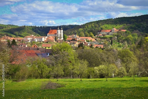 Panoramic view of Lomnice town with Church of the Visitation of the Virgin Mary and castle surrounded by green hills, Czech Republic.