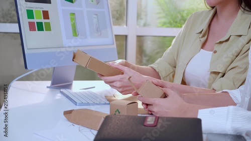 Closeup hand two businesswoman holding cardboard box for packaging design with ai screen at modern office and meeting for paper mockup product, showing eco friendly recycle prototype, creative idea.