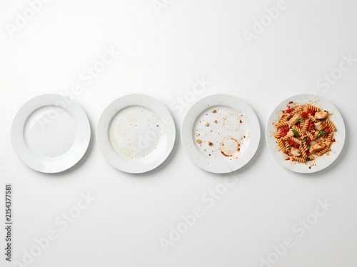 Obraz na płótnie Four white plates showing progressive food consumption from empty to full