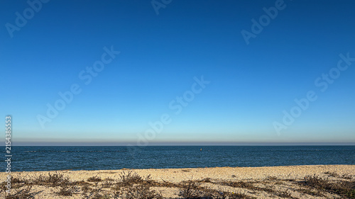 Cuadro en lienzo Minimalist Seascape With Sandy Shoreline and Clear Blue Sky