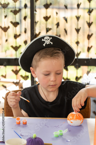 Boy painting pumpkin during Halloween craft activity