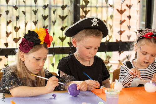 Children painting pumpkins at Halloween craft activity