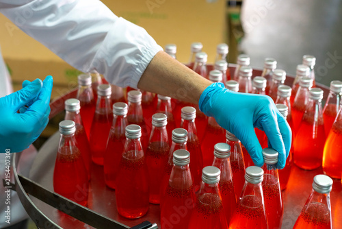 Close-up of the hands  in production line of the factory for bottling beverages. Production of beverages.