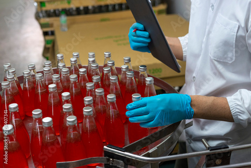 Close-up of the hands  in production line of the factory for bottling beverages. Production of beverages.