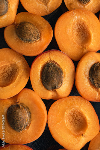 A mountain of fresh, ripe apricots, including whole fruits and pitted halves. Fruit. Harvesting.	
