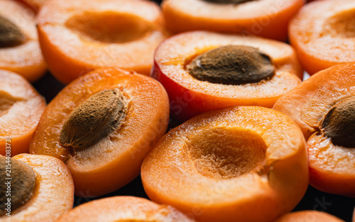 A mountain of fresh, ripe apricots, including whole fruits and pitted halves. Fruit. Harvesting.	

