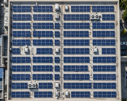 Aerial view of industrial commercial rooftop solar panel array with industrial sustainable renewable electricity building photovoltaic structure