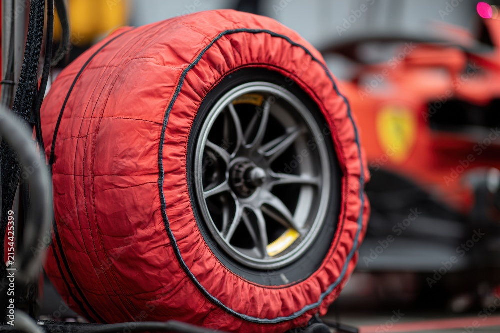 Fototapeta premium Formula Racing Tire Covered with Red Thermal Tire Warmer, Motorsport Detail