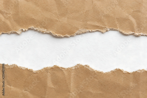 Torn brown kraft paper background, ripped cardboard edges with white copy space, textured recycled paper frame for message