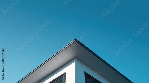 Minimalist Architectural Corner of a Modern White Building Against a Clear Vibrant Blue Sky Background