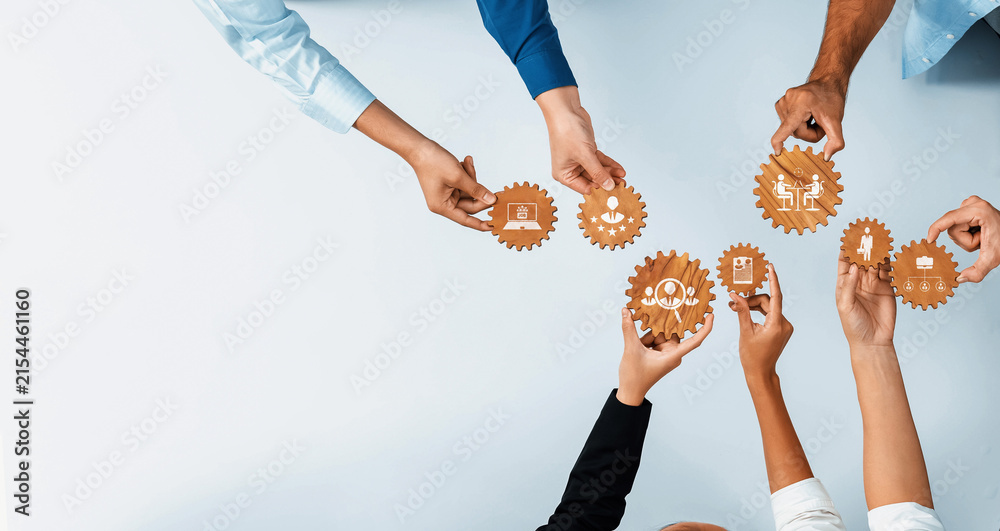 Obraz premium A diverse group of hands holding gears that symbolize teamwork, innovation, and technology in a modern business context, highlighting collaboration and mutual goals. Amity