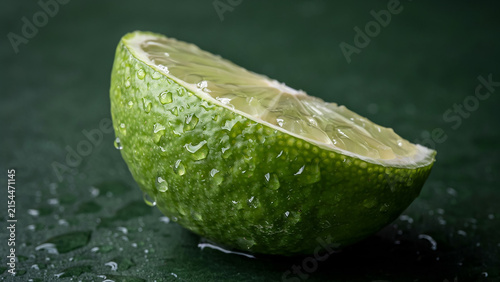 Single piece of fresh lime fruit with water condensation on dark background droplets ingredient refreshing nutrition culinary moisture beverage