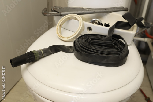 Obraz na plátně Plumbing tools and replacement parts lying on a white toilet lid during a bathroom repair process