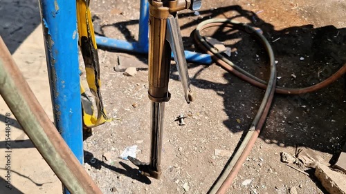 Close-up of industrial oxy-acetylene cutting torch and hoses on a construction site ground