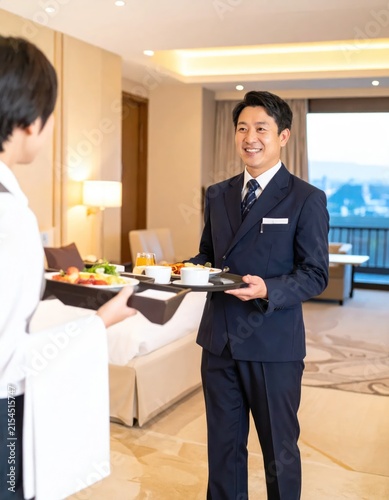 Hotel waiter serving breakfast tray in luxury suite room.