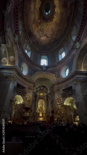 Prague, Czechia republic 17 june 2026 :Low angle view of ornate baroque church interior showcasing painted dome ceiling, altar, and golden decorative details. Majestic historic religious architecture.