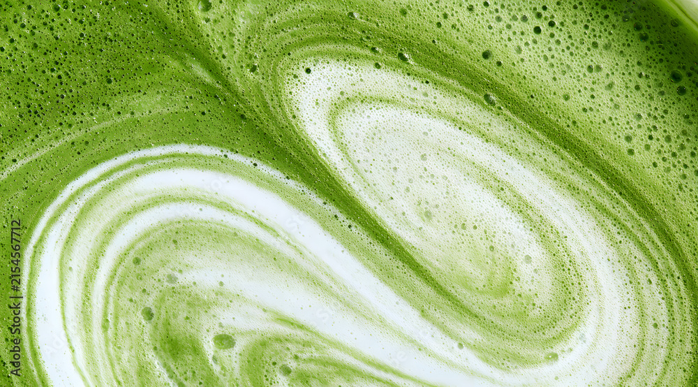 Fototapeta premium a frothy matcha latte, known for its distinctive emerald hue and subtle swirls of creamy foam, captured in both macro and wide-angle shots, featuring a detailed texture close-up and viewed from the to